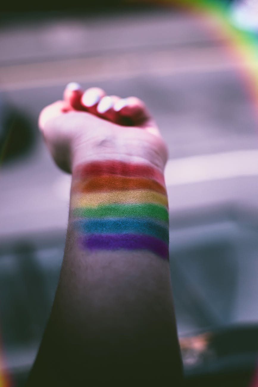 person with rainbow color paint on his wrist