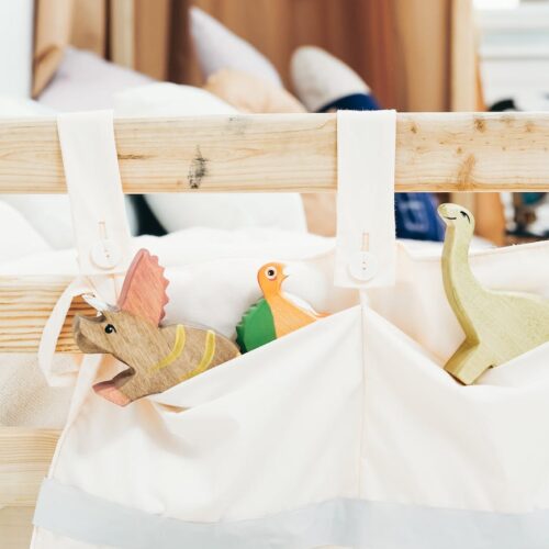 white cloth bag with brown wooden toy figurines